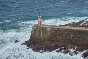 Viavelez lighthouse, asturias, spain, a beacon from above amidst the crashing waves photo