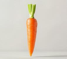 Floating carrot in mid-air concept. Fresh carrot on a simple background with green tops. photo