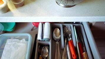 An organized kitchen drawer with utensils, a stocked first aid kit, and neat storage jars enhances storage efficiency and improves overall kitchen functionality and ease of use video
