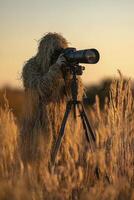 A man in a camouflage suit is taking a picture with a camera photo