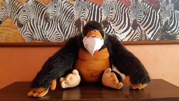 A soft toy gorilla sits in a protective medical mask, creating an unusual and funny image. photo
