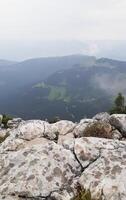 Fog. Rocky mountains illuminated by the bright summer sun, with a blue cloudless sky in the background. photo