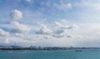Magical sky. The picturesque city is spread out on the seashore. The sun's rays are reflected in the waves photo