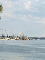 River port, large vessels and small ones stand at the pier, creating a contrast of scales photo