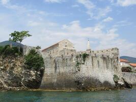Fortress. An ancient coastal fortress built on a rocky island is washed by crystal clear water. Massive stone walls photo