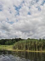 River landscape with thick clouds that hang over the water surface. The calm flow of the river beats the gray sky, photo