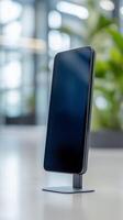 Sleek, modern tablet with blank screen stands on a desk in a well-lit office environment. The minimalist design and clear display make it suitable for digital presentations. photo