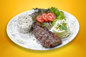 Beef steak with potatoes and rice in isolated white background. photo