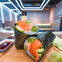 A sushi roll with salmon and cucumber on top photo
