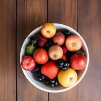 A bowl of fruit on a wooden table photo