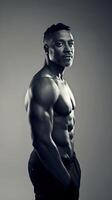 A man with no shirt on posing in front of a gray background photo