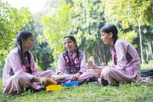 Two Creative Girl Students Are Sitting In The Park One Of Whom Is Staring At The Camera photo