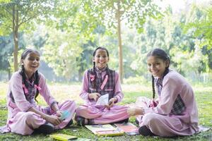 Three Girl Best Friends Are Sitting In The Park And One Of Them Is Giving Her Sandwich To Another Girl photo