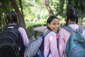Indian Village Girl Shy Student Standing While Holding Slate In Hand With Written Text ''Back To School'' photo