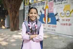 Close-Up View Of Happy Kid Holding Book In Hand While Posing In Front Of Camera photo