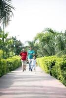 Son Running In Park With Father And Grandpa photo