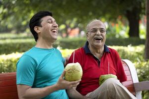 Happy Father And Son Having Fun While Drinking Coconut Water photo