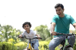 Dad And Son Ride On Bikes In Park photo