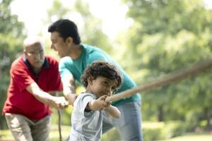 Smart Kid Playing Tug Of War In Park photo