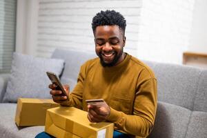 Young male shopper man completes transaction using mobile app and credit card details for an online purchase, demonstrating the simplicity of mobile payment systems. photo