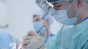 Operation of removing tonsils under deep anesthesia, surgeon uses latest devices, cold plasma method, cuts swelling in throat, doctor works with new probe, medical headlamp, surgical loupes 9 video