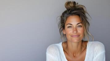 A woman with a messy bun and a white shirt photo