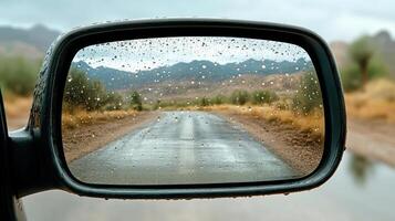 A side view mirror with rain on the road photo