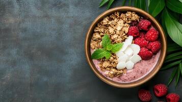 Raspberry yogurt smoothie with granola and mint leaves on dark background photo
