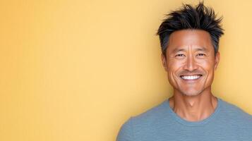 A man with short hair and a gray shirt smiles photo