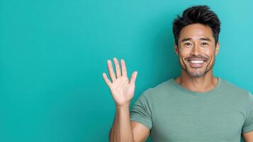 A man is waving his hand in front of a green background photo