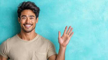 A man is waving his hand in front of a blue wall photo