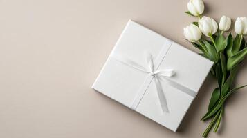 White tulips and gift box on beige background photo