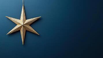 Gold star hanging on blue wall photo