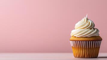 A cupcake with white frosting on a pink background photo