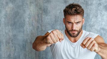 A man with a beard and a white shirt is showing his fists photo