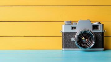 Retro camera on yellow wooden background photo
