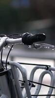 Bicycles for rent in the city center . Close-up after the rain. In the background, a passing vehicle is out of focus. video