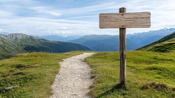 A wooden sign on a path in the mountains photo