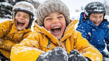 Three children in yellow jackets laughing in the snow photo