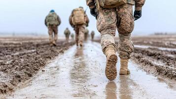 Marines walk through muddy field photo