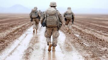 Soldiers walking in the mud on a field photo