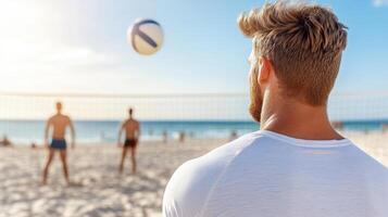 A man is standing on the beach with a volleyball ball photo