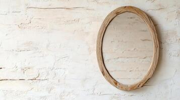 A wooden oval mirror on a white wall photo