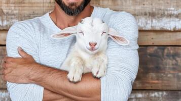 A man holding a baby goat photo