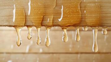 A close up of dripping honey on a wooden surface photo