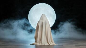 A person in a cloak standing in front of a full moon photo