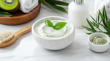 A bowl of green facial cream, a brush, and a towel photo