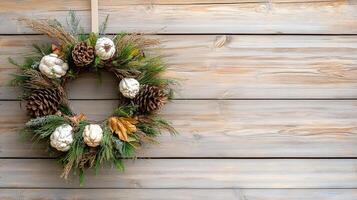 A wreath with pine cones and other decorations on a wooden wall photo