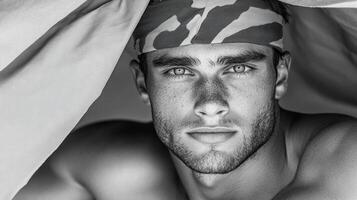 A man with a camo headband is looking at the camera photo