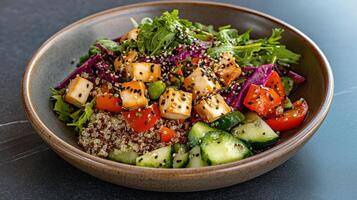 A bowl of salad with tofu, vegetables and other ingredients photo